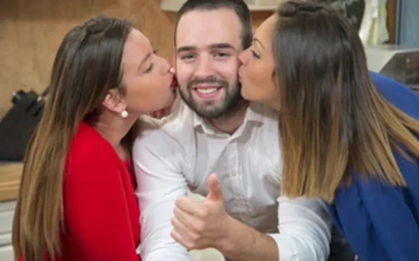 Мужчину одновременно целуют две женщины