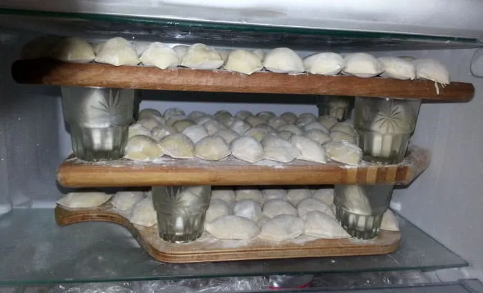 Заморозить много пельменей можно, сделав в морозилке ярусы с помощью кружек или баночек