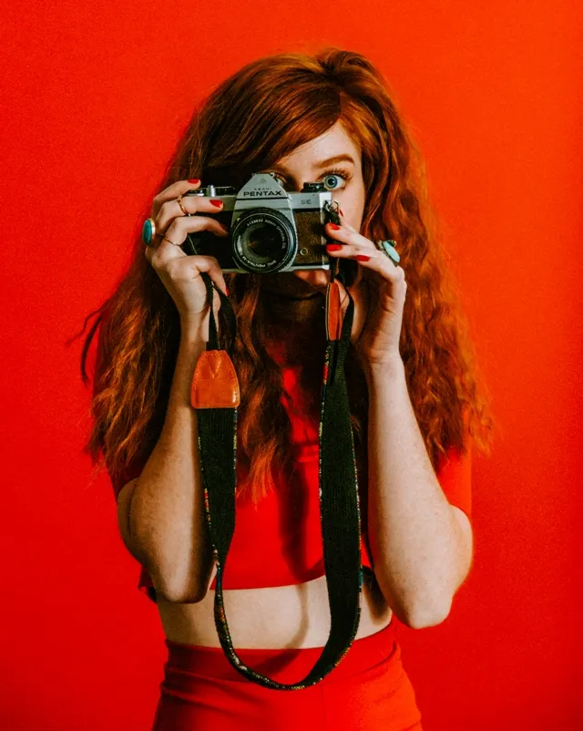рыжеволосая девушка с фотоаппаратом