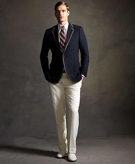 Модель в белых брюках, темно-синий приталенный пиджак, галстук в полоску в стиле Гетсби