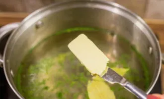 Когда бульон станет горячим, добавьте кусочек сливочного масла, чтобы пельмени не слиплись при варке.