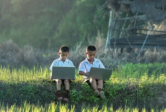 Два мальчика на природе за ноутбуками