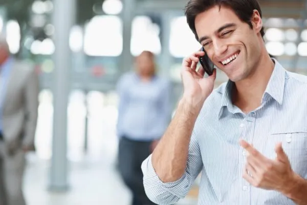 мужчина улыбается во время разговора по телефону
